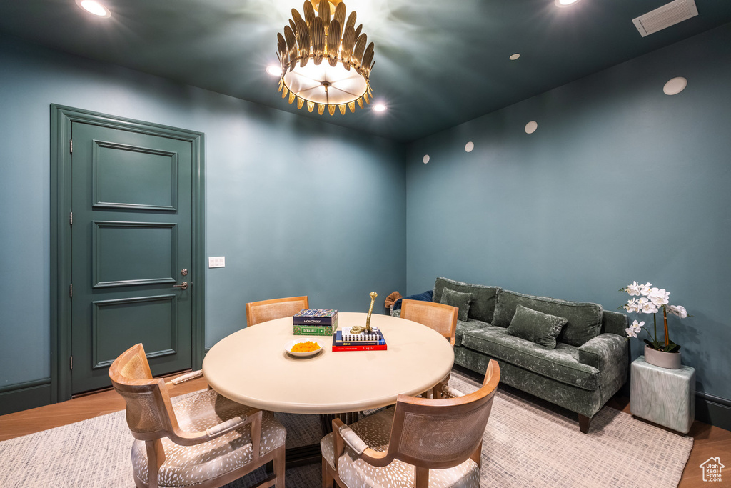 Dining space featuring wood-type flooring and an inviting chandelier