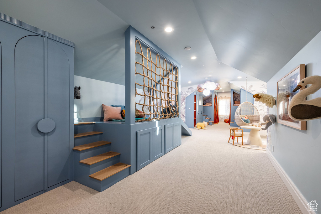 Additional living space featuring light colored carpet and lofted ceiling