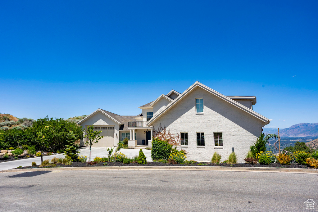 Traditional-style home featuring concrete driveway, a mountain view, brick siding, and an attached garage