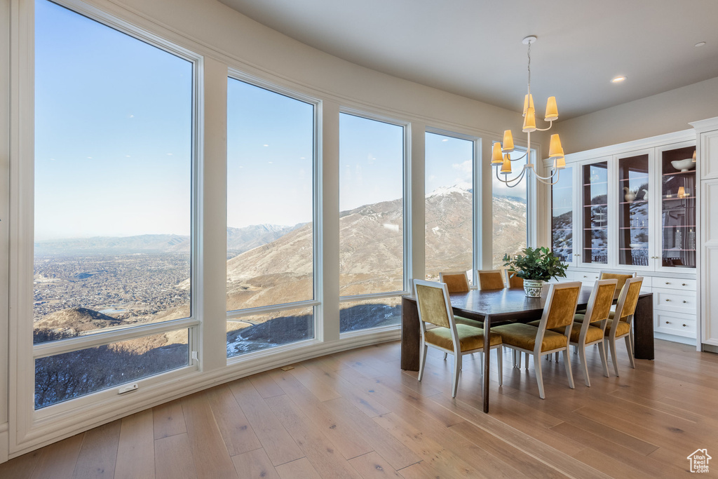 Dining room with a notable chandelier, a mountain view, and light wood-type flooring