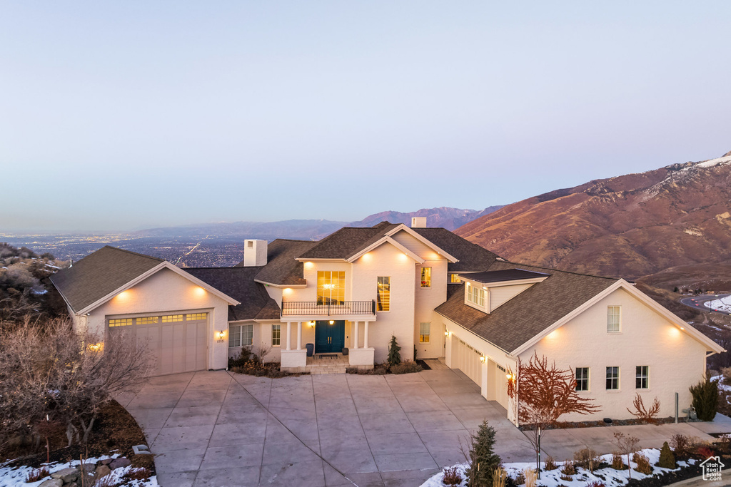 View of front of property featuring a mountain view, a balcony, and a garage