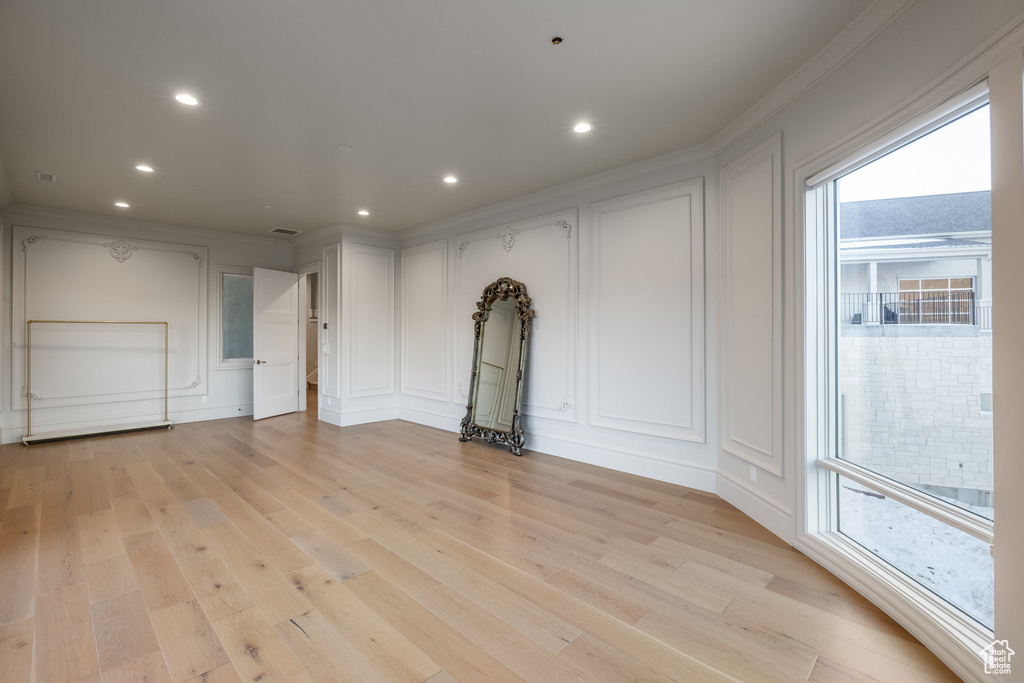 Interior space with light wood-type flooring and crown molding