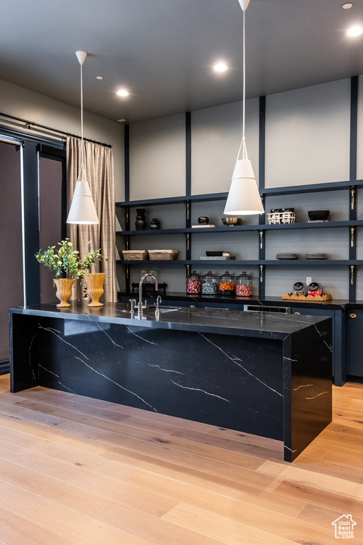 Kitchen with open shelves, light wood finished floors, pendant lighting, and recessed lighting