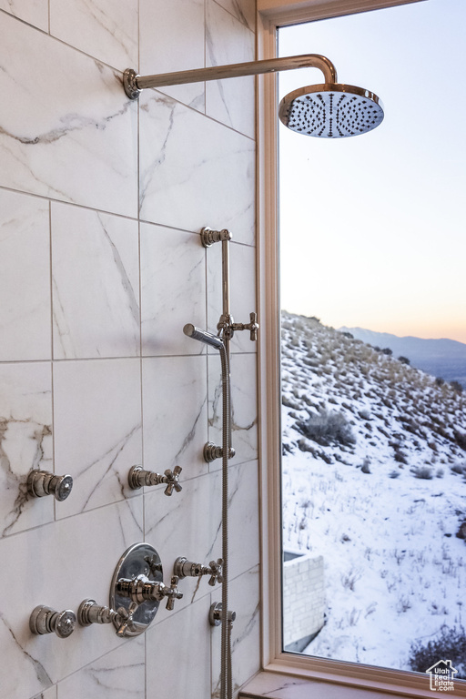 Full bath with tiled shower and a mountain view