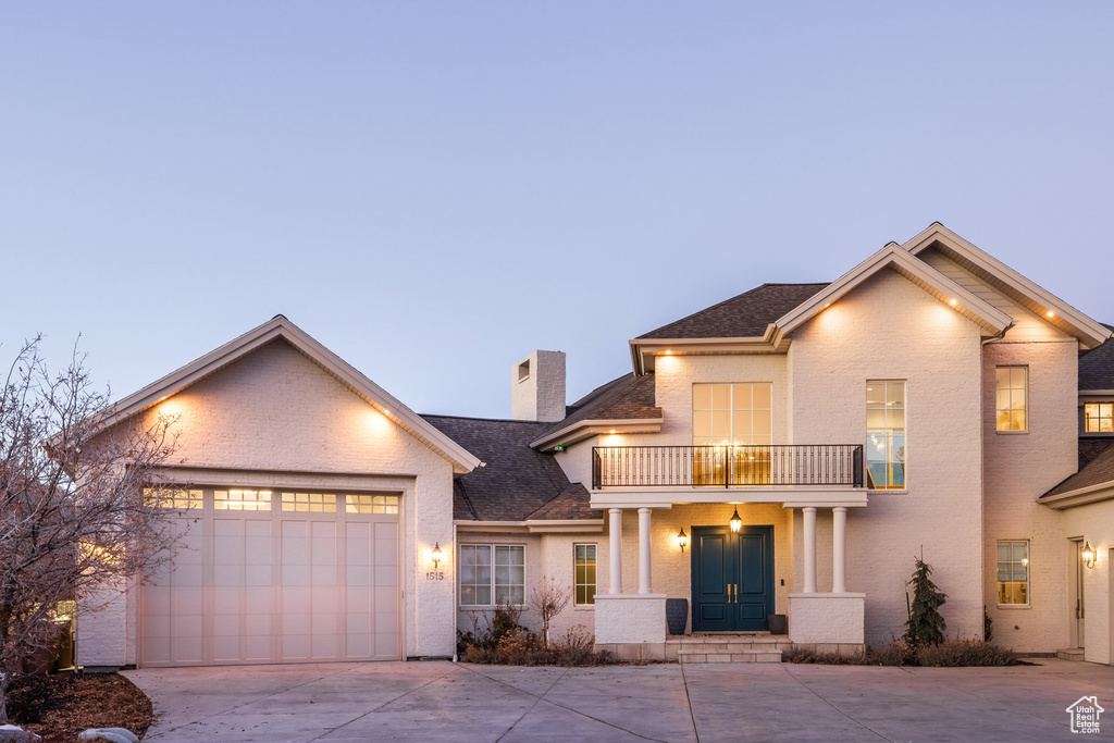 View of front facade featuring a balcony and a garage