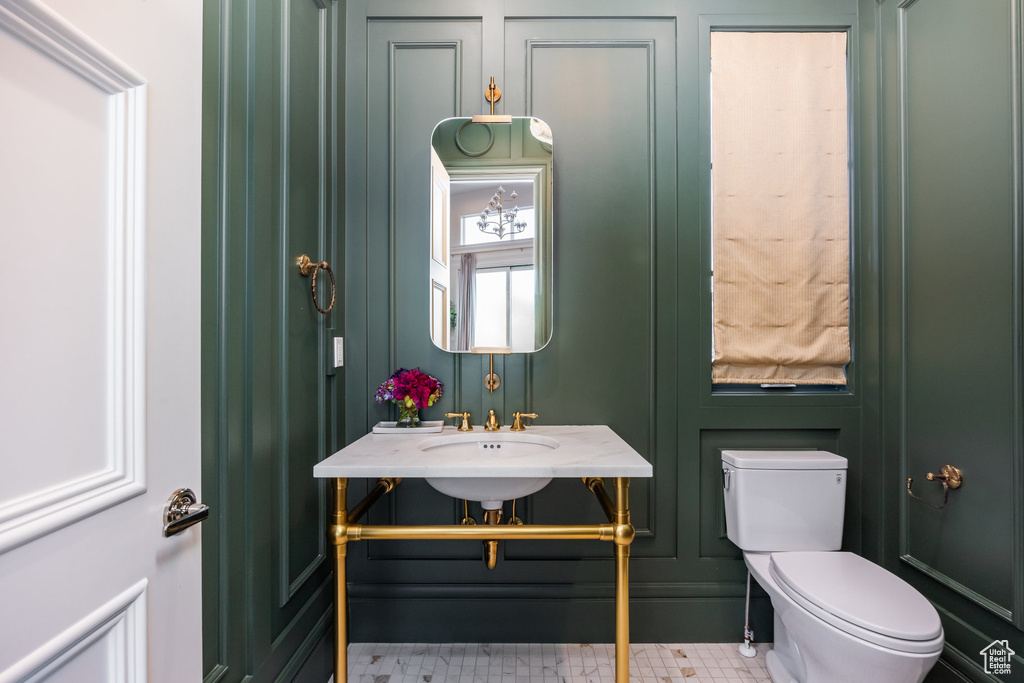 Half bath with toilet and a decorative wall