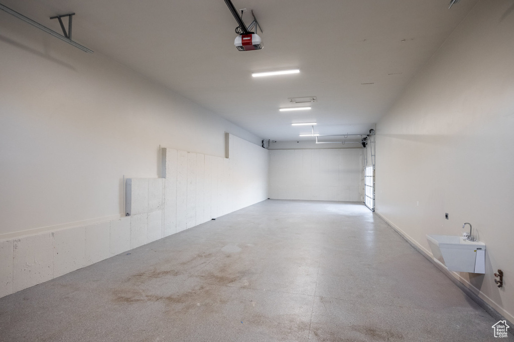 Garage featuring a garage door opener and sink