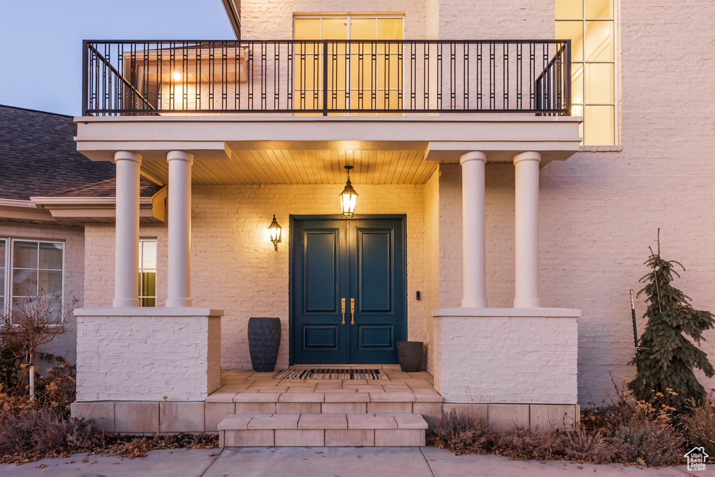 Entrance to property with a balcony and covered porch
