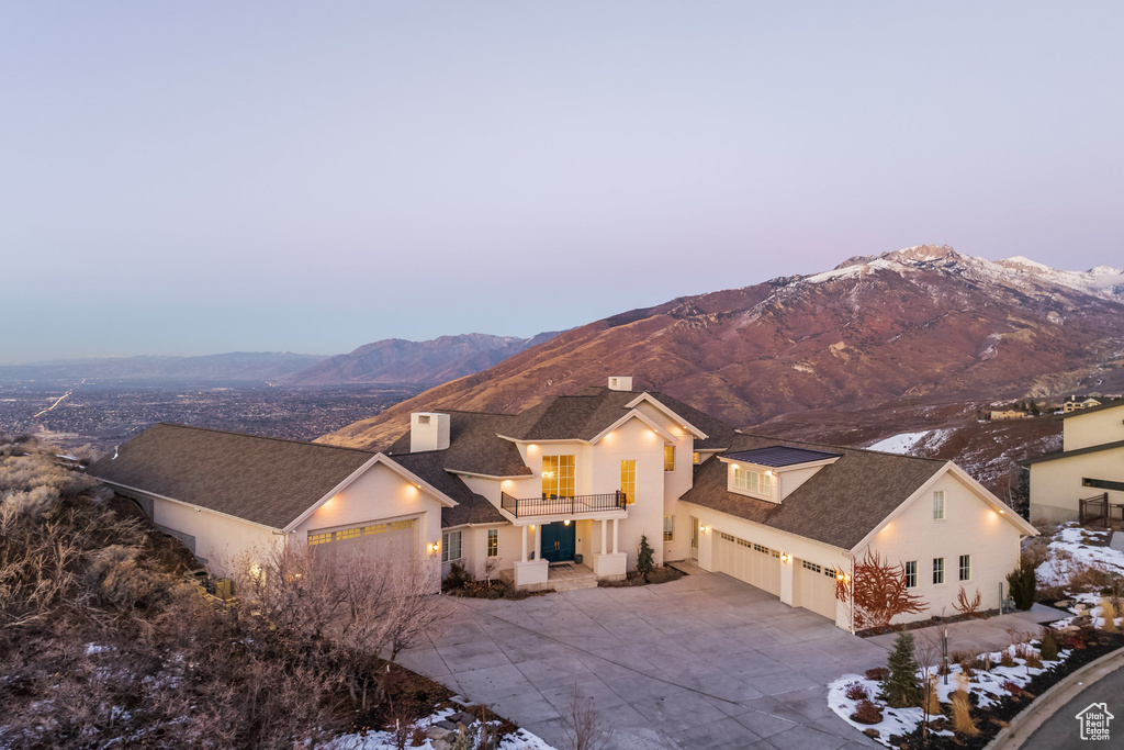 View of front facade featuring a balcony, a garage, driveway, and a mountain view