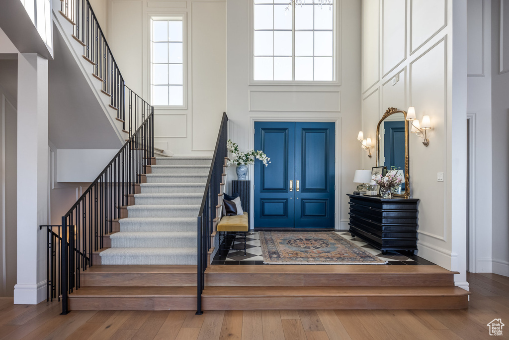 Entryway with wood-type flooring and a towering ceiling