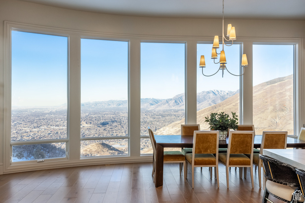 Dining room featuring a mountain view, a chandelier, a wealth of natural light, and hardwood / wood-style flooring
