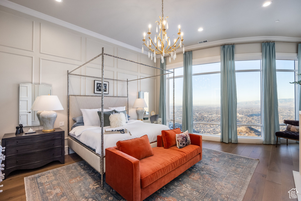 Bedroom featuring multiple windows, crown molding, dark hardwood / wood-style floors, and an inviting chandelier