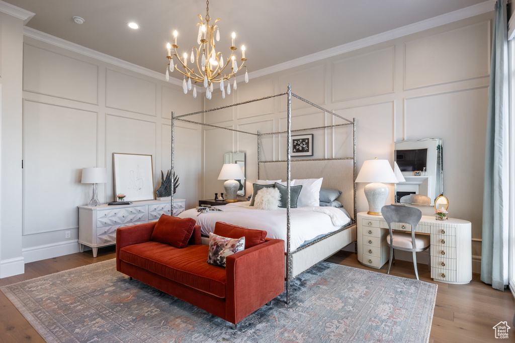 Bedroom with a decorative wall, ornamental molding, a chandelier, wood finished floors, and recessed lighting