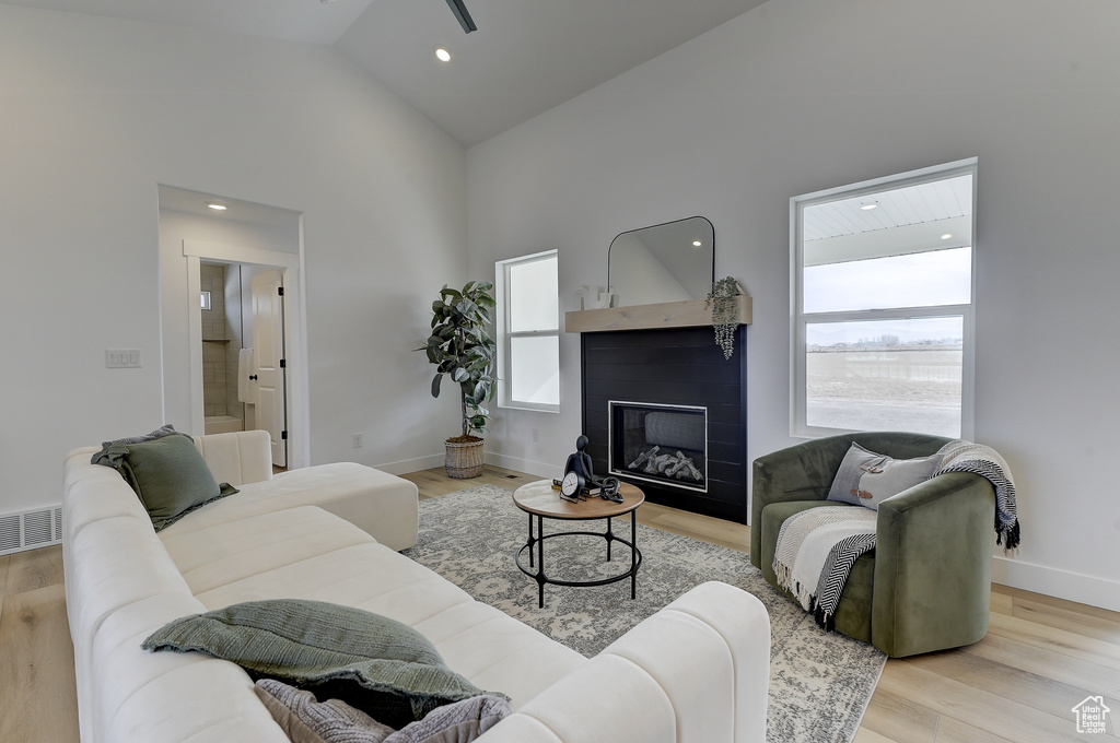 Living room featuring high vaulted ceiling and light hardwood / wood-style floors