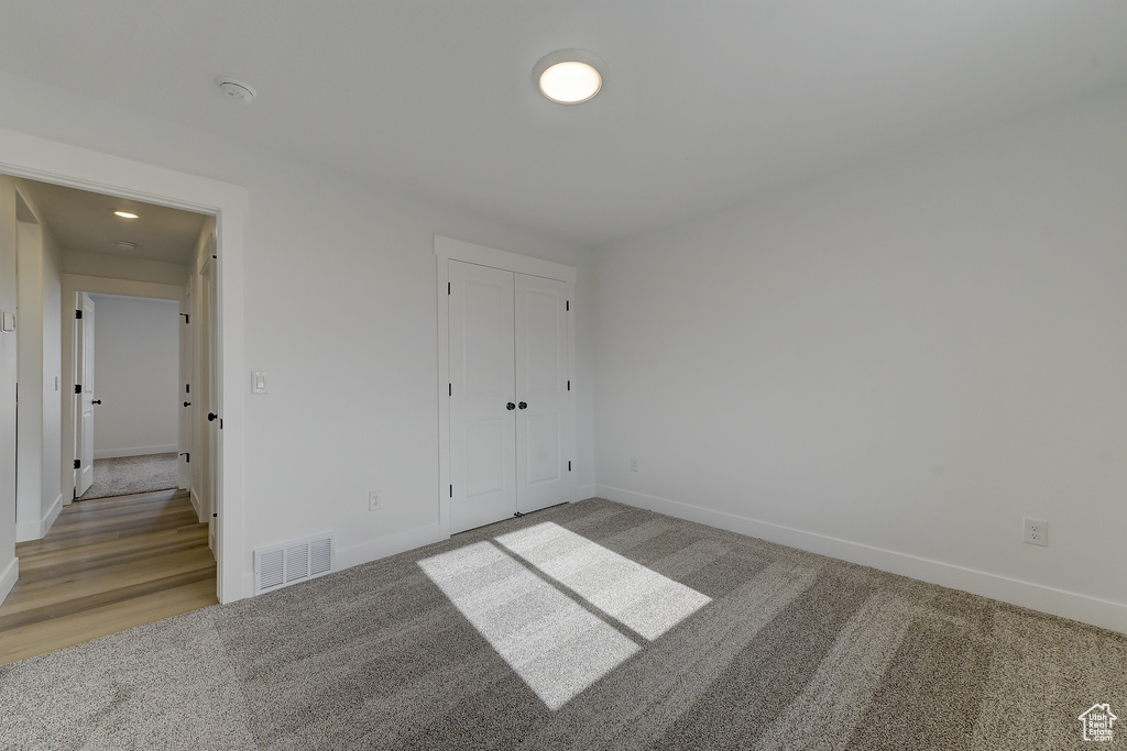 Unfurnished bedroom featuring carpet and a closet