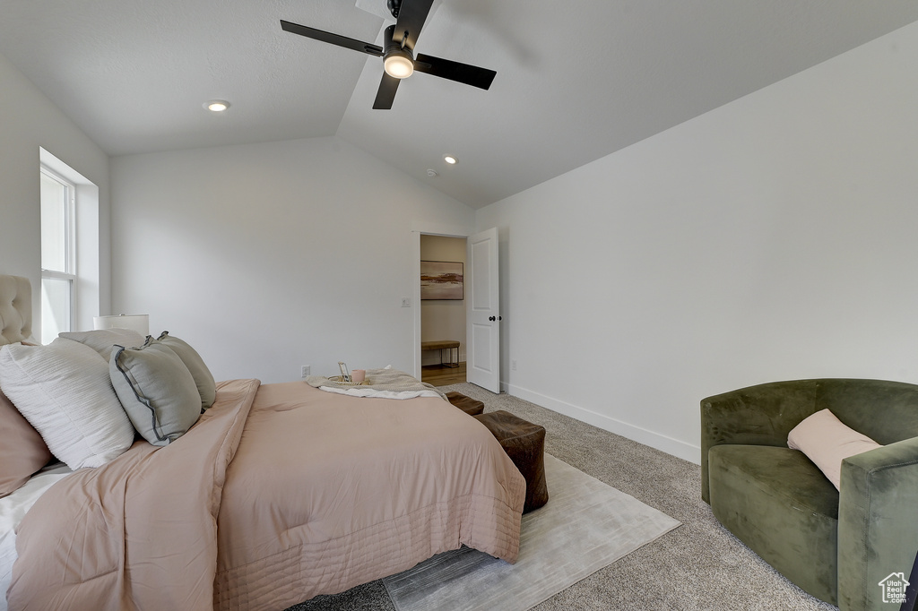 Bedroom featuring ceiling fan, light colored carpet, and vaulted ceiling