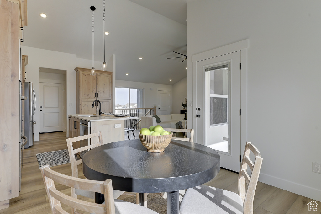 Dining space with light hardwood / wood-style floors and sink