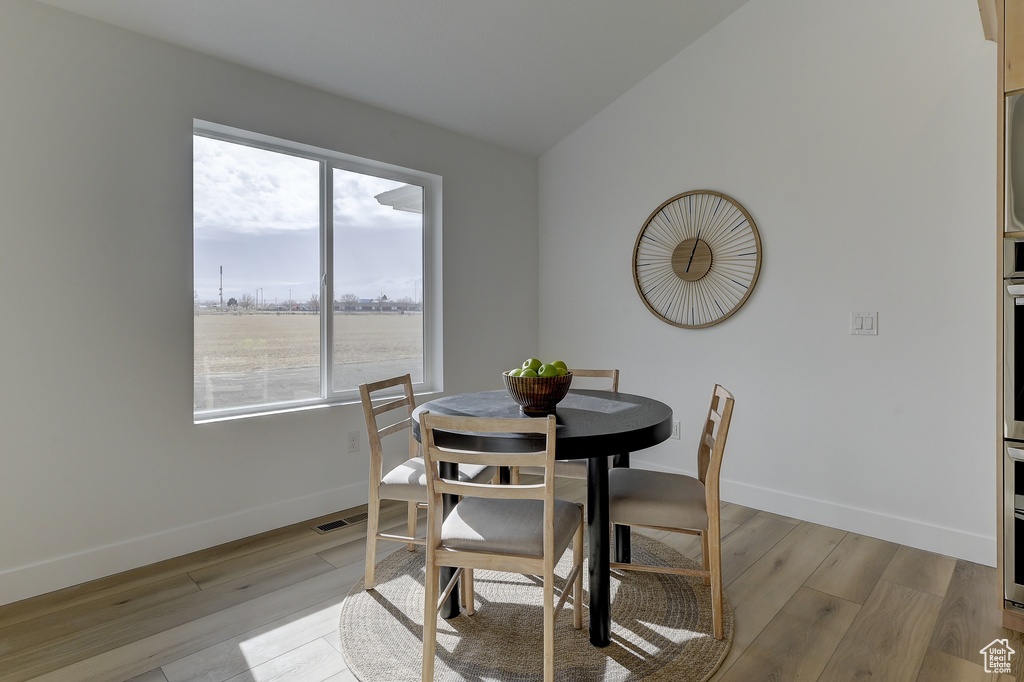 Dining room featuring lofted ceiling and light hardwood / wood-style floors