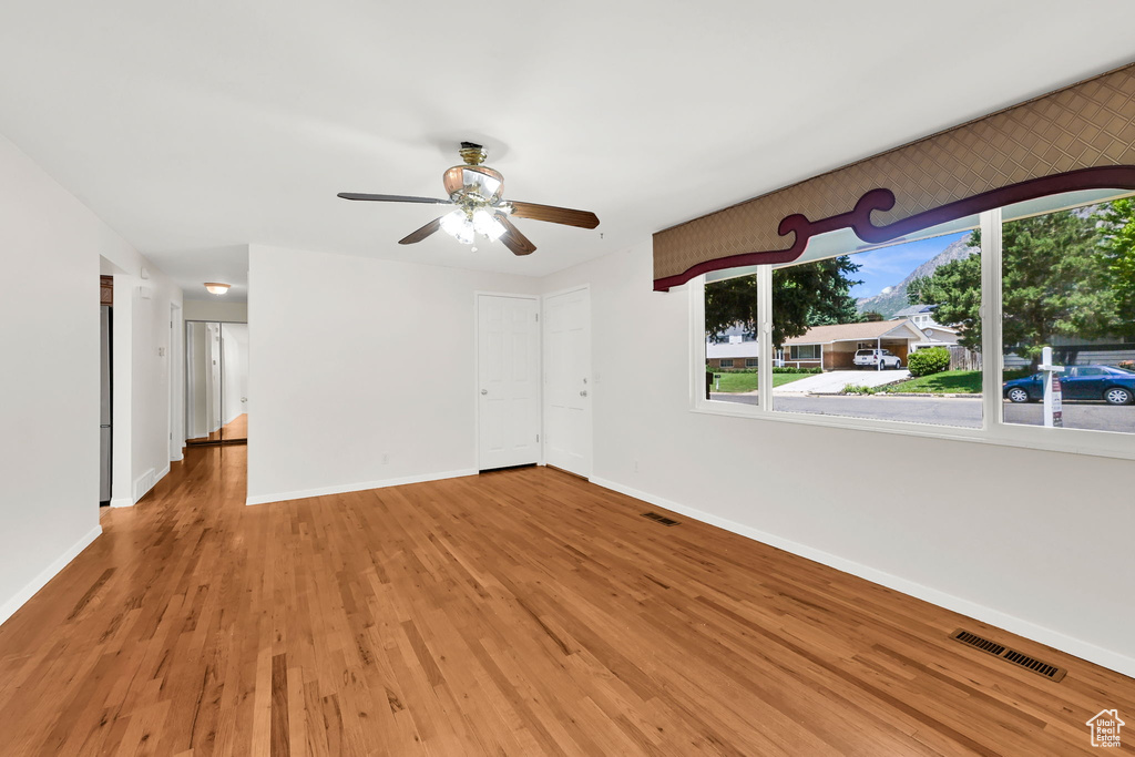 Unfurnished room with baseboards, wood finished floors, and ceiling fan
