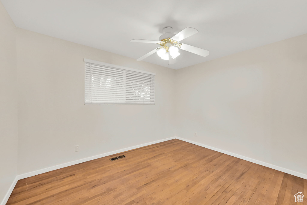 Spare room with light wood finished floors, baseboards, and ceiling fan