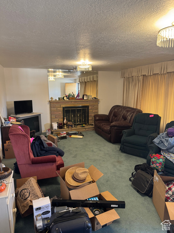 Living room with a fireplace, carpet floors, and a textured ceiling