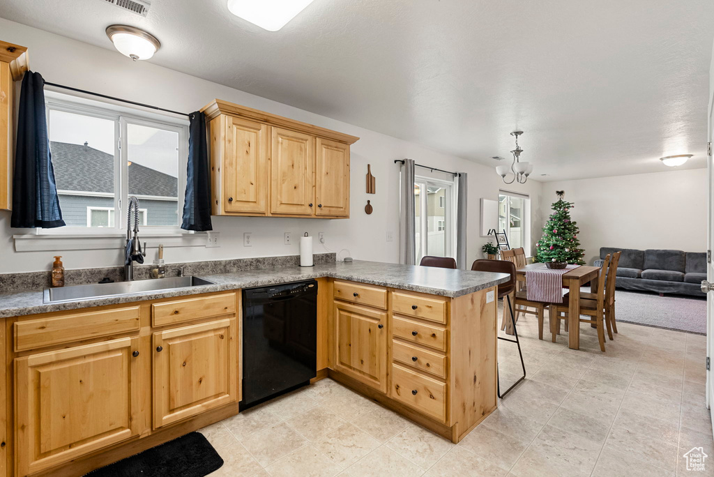 Kitchen featuring dishwasher, kitchen peninsula, sink, and an inviting chandelier