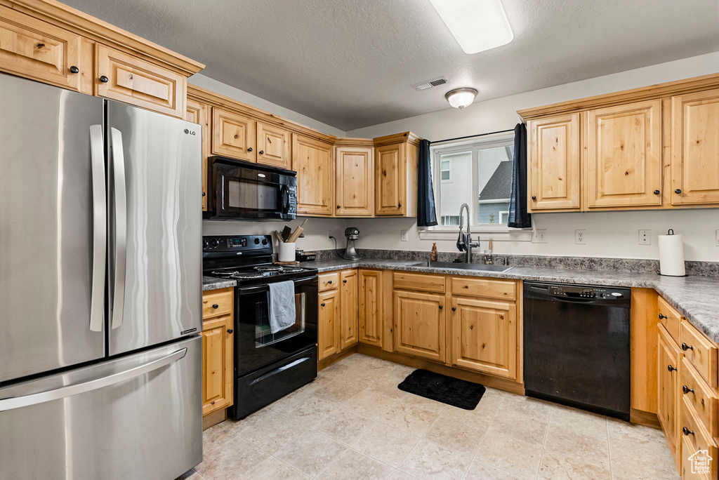 Kitchen featuring black appliances, sink, and a textured ceiling