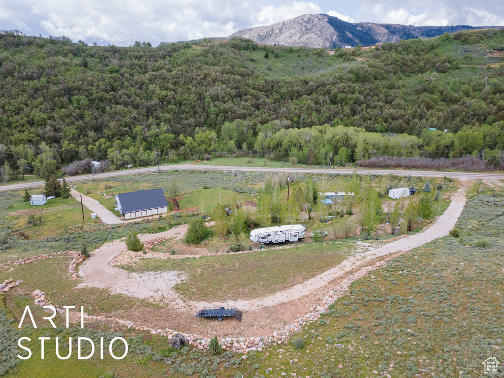 Aerial overview of property's location with a heavily wooded area and a mountain backdrop