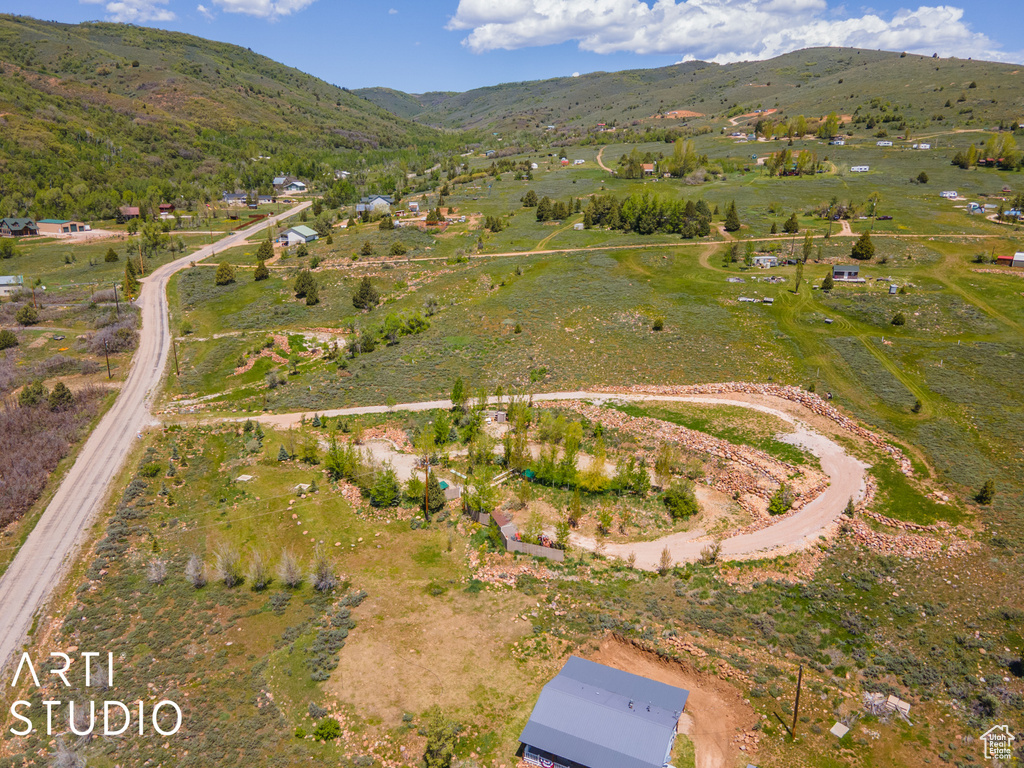 Aerial view of property and surrounding area with a mountainous background and rural landscape