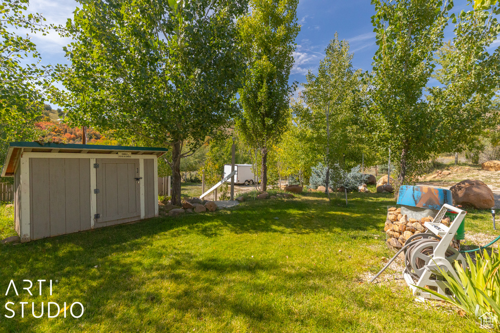 View of grassy yard with a shed and an outdoor structure