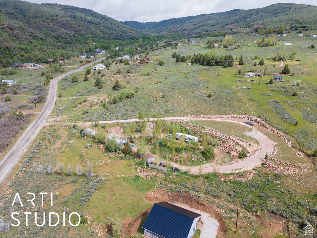 Aerial view of property and surrounding area featuring mountains and rural landscape