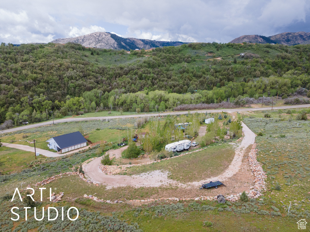 View from above of property featuring a heavily wooded area and a mountain backdrop