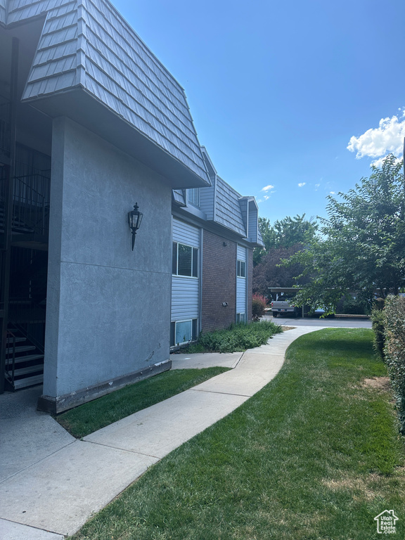 View of side of home featuring a lawn