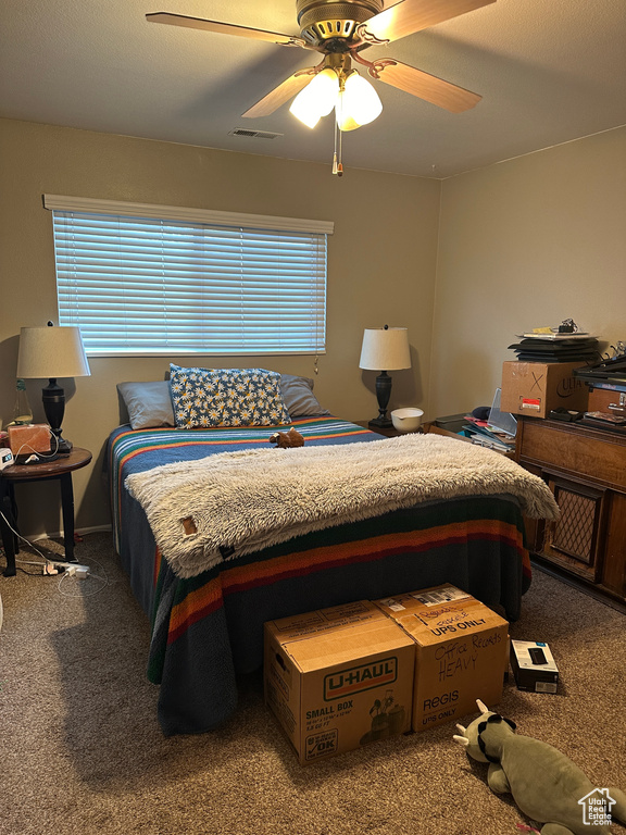 Carpeted bedroom featuring ceiling fan