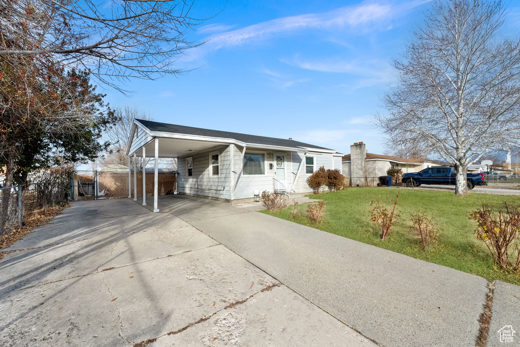 Ranch-style house with a carport and a front yard