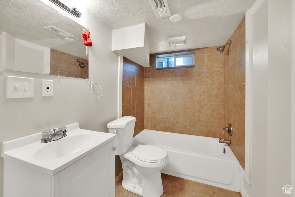 Bathroom featuring vanity, bathing tub / shower combination, tile patterned flooring, and a textured ceiling