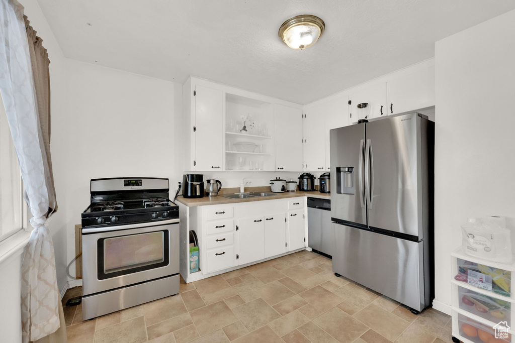 Kitchen featuring white cabinetry, sink, and appliances with stainless steel finishes