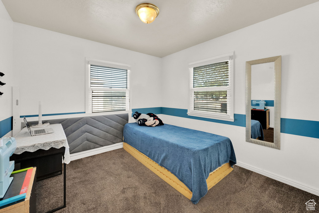 Bedroom featuring carpet floors and baseboards