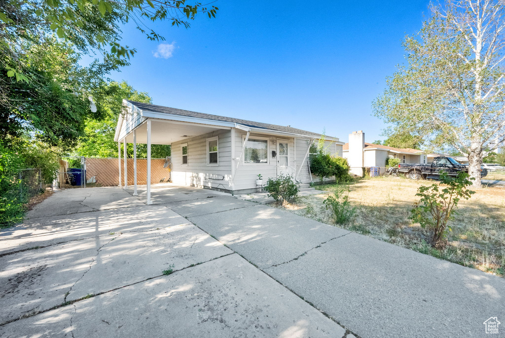 View of front facade with concrete driveway and an attached carport