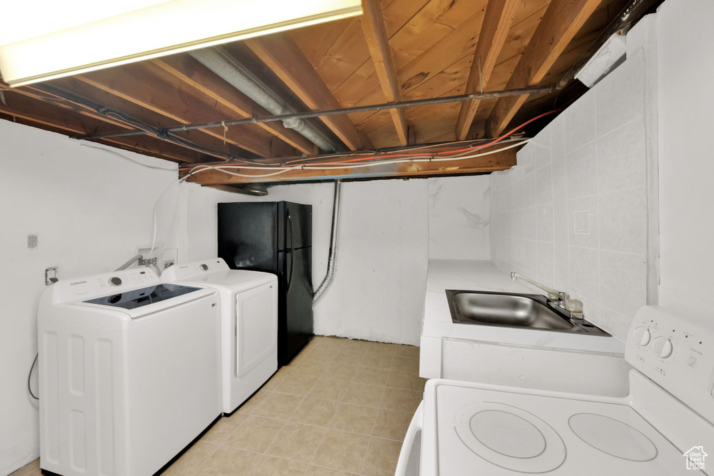 Washroom featuring washing machine and dryer and light tile patterned flooring