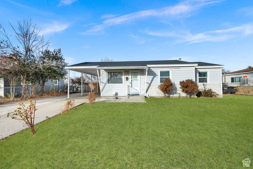 View of front of house with a carport and a front yard