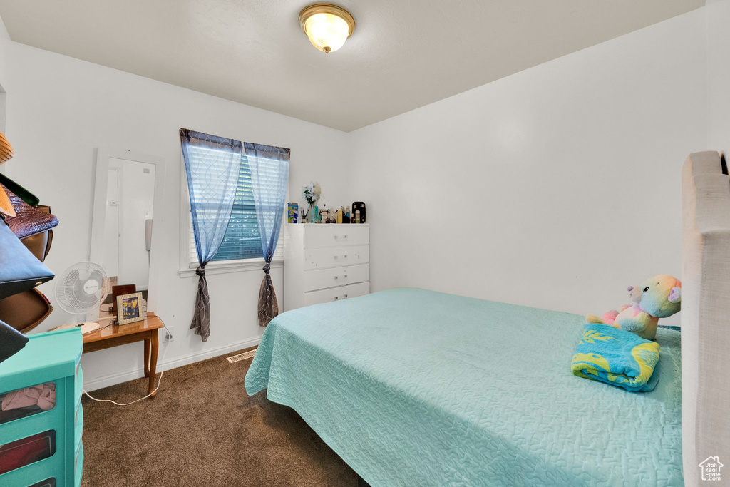 Bedroom featuring dark colored carpet and baseboards