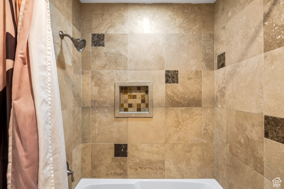 Bathroom with shower / bath combination with curtain