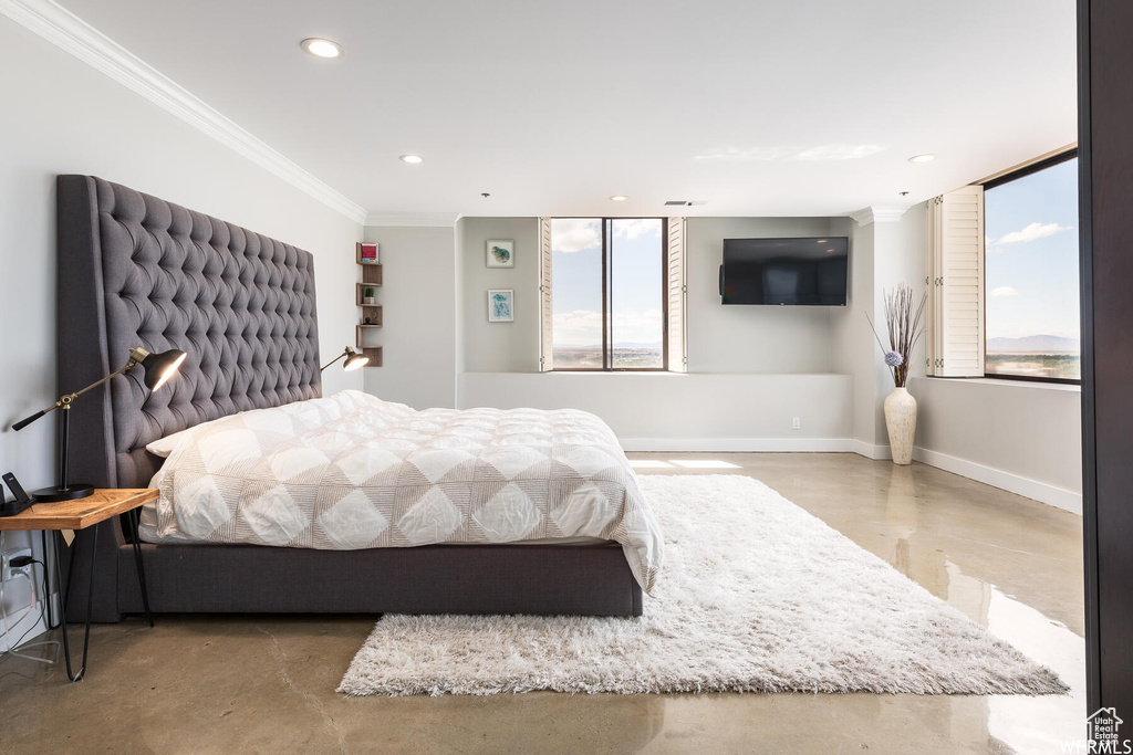 Bedroom with concrete floors and ornamental molding