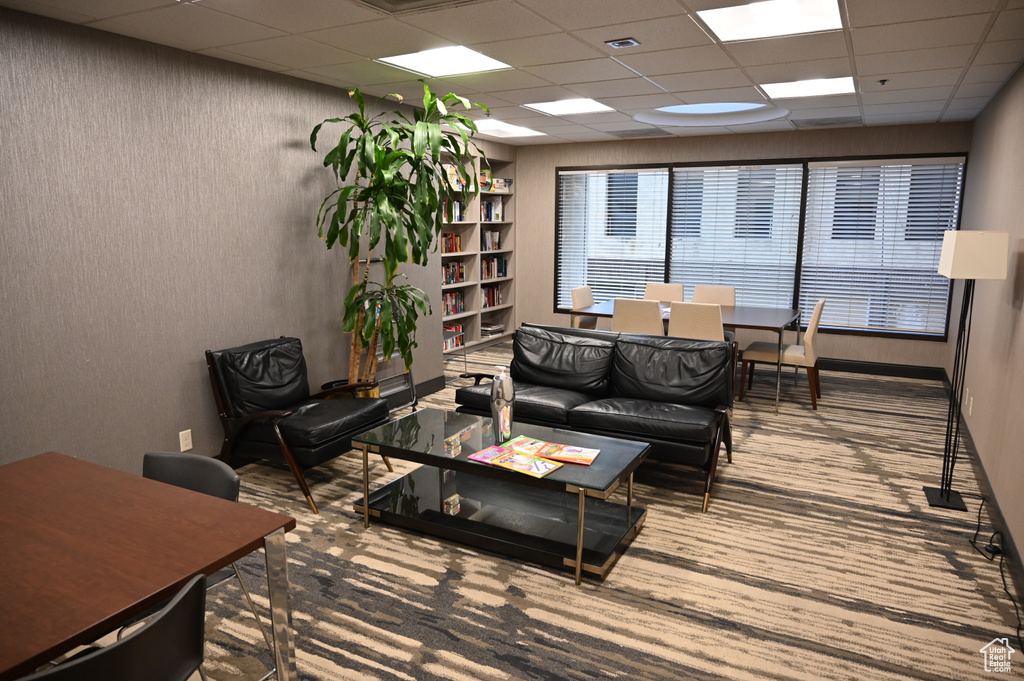 Living room with a drop ceiling and built in features