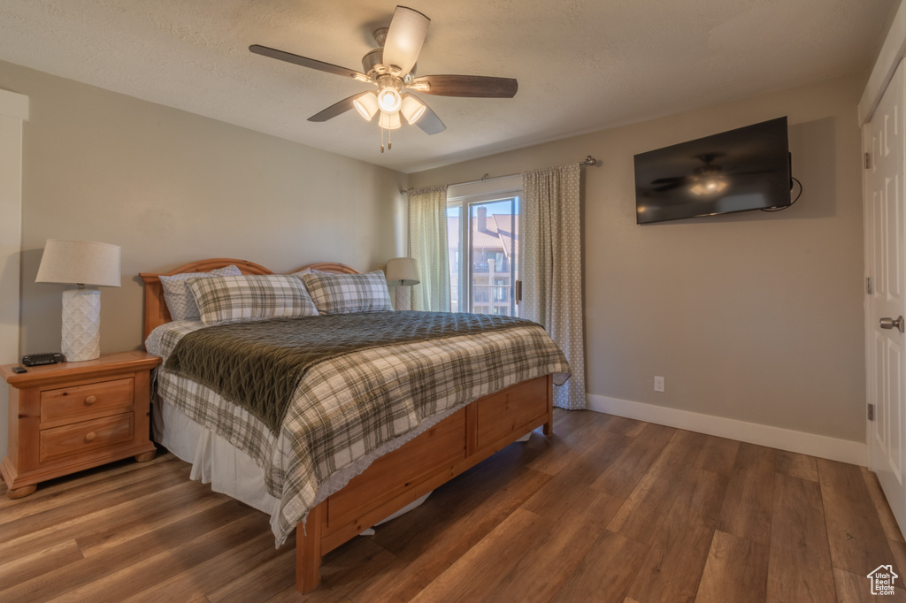 Bedroom with ceiling fan and dark wood-type flooring