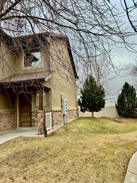 View of property exterior featuring a yard and a patio area
