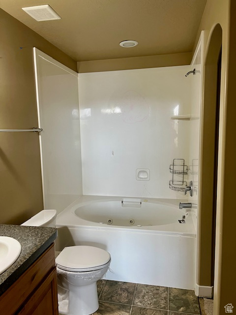 Full bath with vanity, toilet, visible vents, and a combined bath / shower with jetted tub