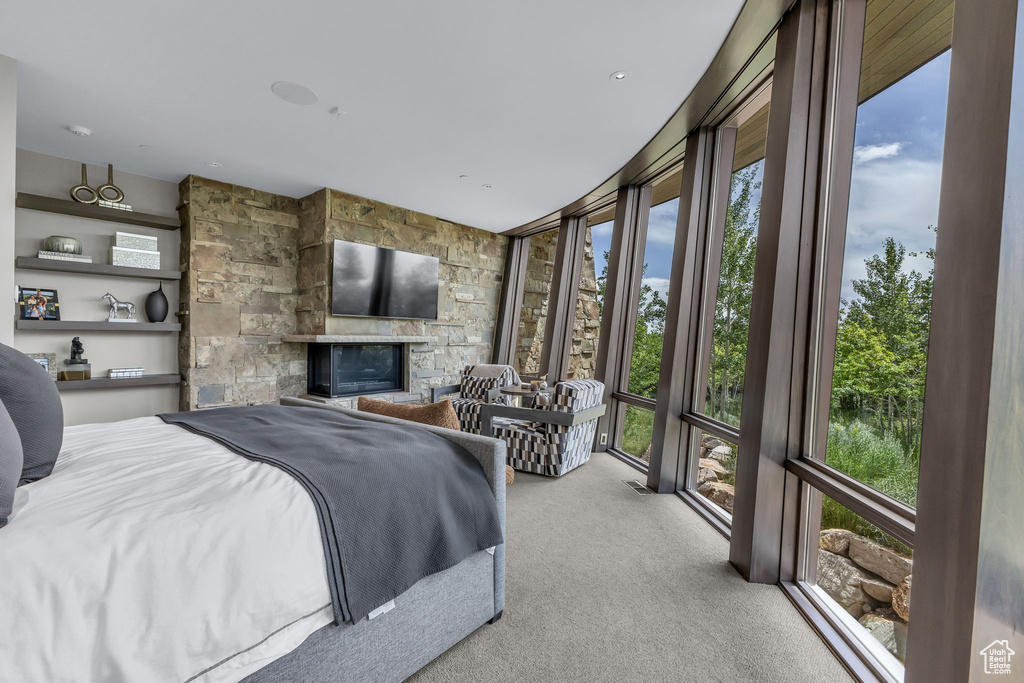 Carpeted bedroom with a stone fireplace