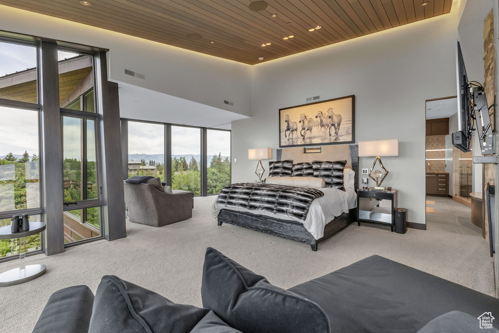 Bedroom with carpet flooring, wood ceiling, recessed lighting, and a towering ceiling